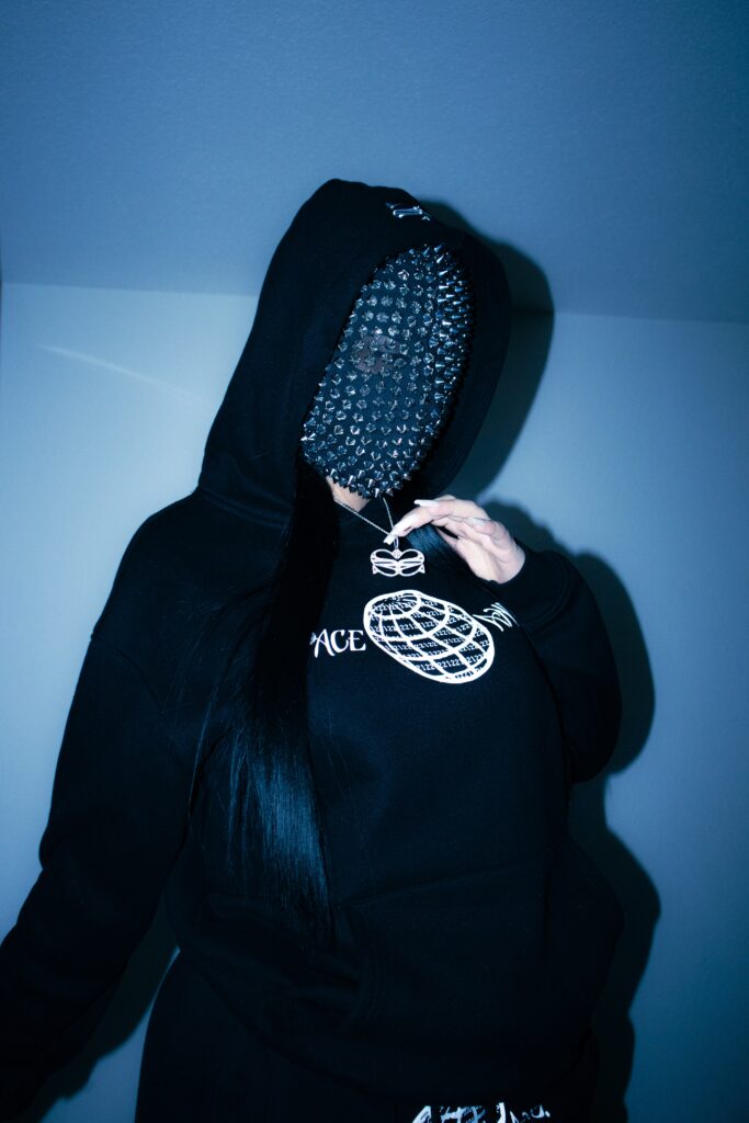 a woman in a black hoodie with spikes on her head